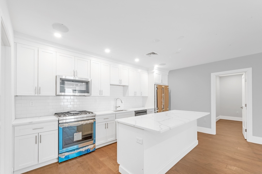 a kitchen with stainless steel appliances a white stove top oven cabinets and a refrigerator