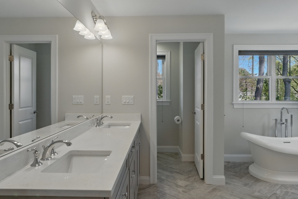 186 Concord Road Bedford, MA 01730 - Photo 19 of 40 a spacious bathroom with a double vanity sink a large mirror and a shower