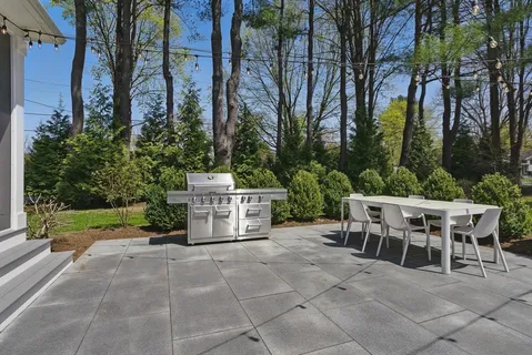 a view of a chairs and table in the back yard of the house