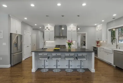 a kitchen with stainless steel appliances kitchen island granite countertop a refrigerator and a stove top oven