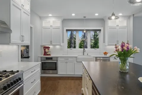a kitchen with kitchen island granite countertop a sink stainless steel appliances and cabinets
