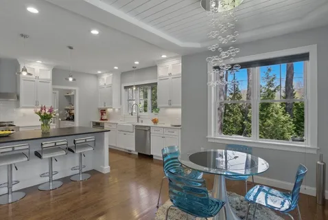 a kitchen with sink refrigerator dining table and chairs