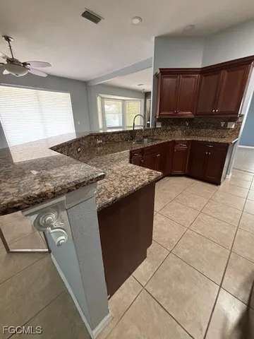 a kitchen with granite countertop a sink a stove and cabinets