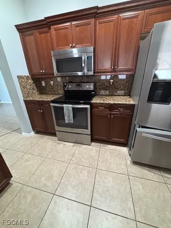 a kitchen with granite countertop a stove a sink and a microwave