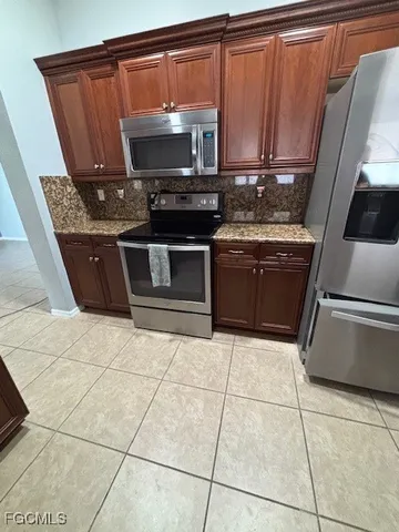 a kitchen with granite countertop a stove a sink and a microwave