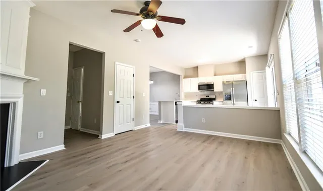 a view of a kitchen with wooden floor and a window