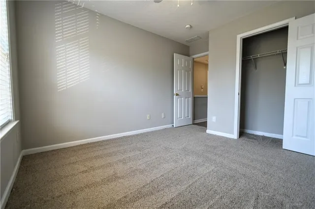 an empty room with windows and closet