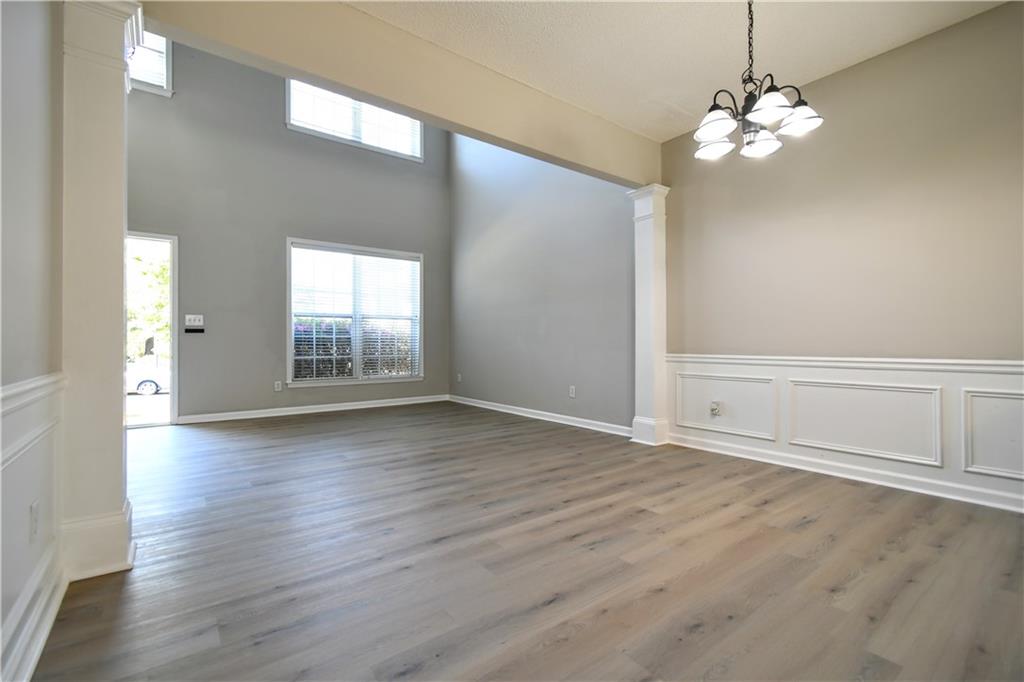 3905 Timbercreek Circle Roswell, GA 30076 - Photo 5 of 30 an empty room with wooden floor chandelier and windows