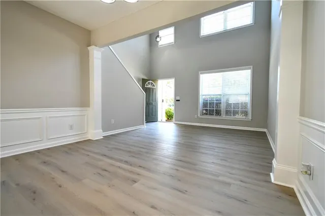 an empty room with wooden floor and windows