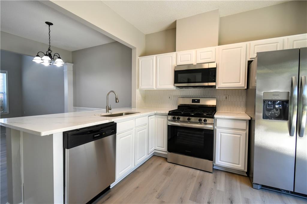 3905 Timbercreek Circle Roswell, GA 30076 - Photo 10 of 30 a kitchen with stainless steel appliances granite countertop a sink stove and refrigerator