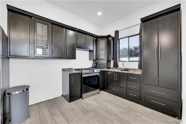 a kitchen with stainless steel appliances granite countertop a stove a sink and a refrigerator