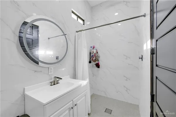a bathroom with a sink a mirror and shower