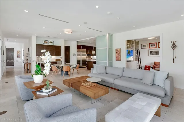 a living room with furniture kitchen view and a window