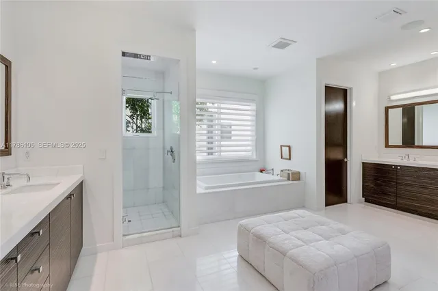 a spacious bathroom with a tub sink shower and mirror