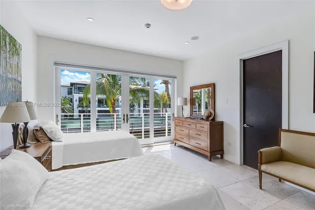 a bedroom with furniture and a large window