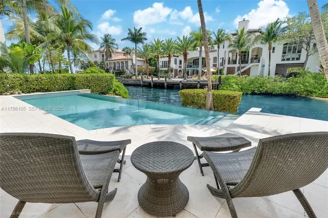 a view of a patio with table and chairs potted plants and palm trees