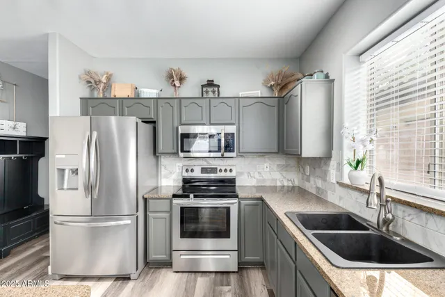 a kitchen with stainless steel appliances a refrigerator sink and microwave