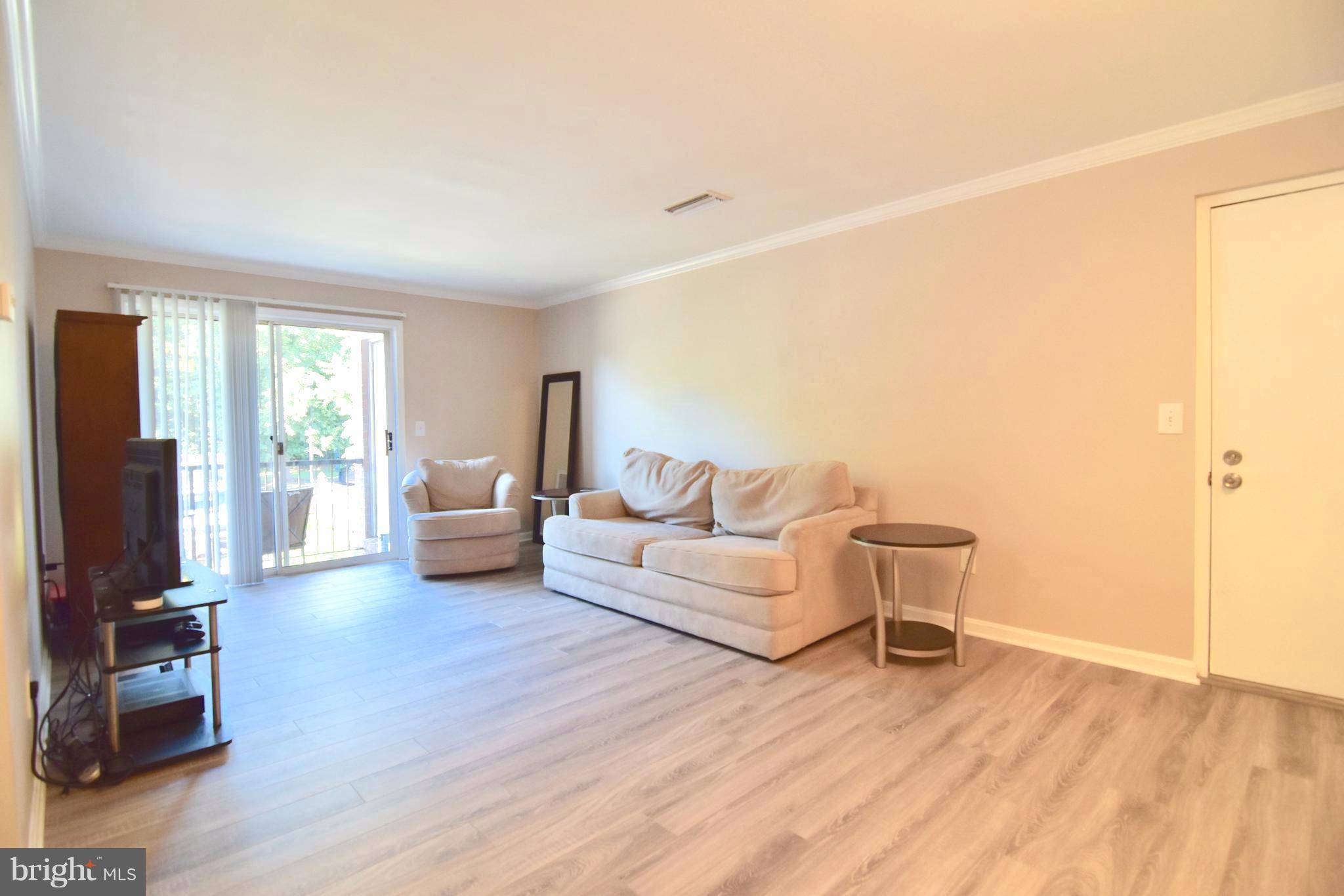 14903 Rydell Road, Unit 204 Centreville, VA 20121 - Photo 3 of 16 a living room with furniture and a wooden floor