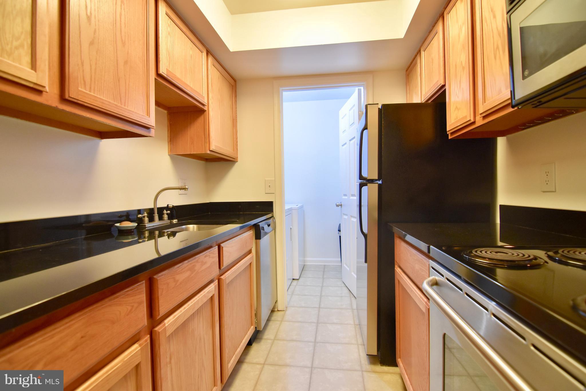 14903 Rydell Road, Unit 204 Centreville, VA 20121 - Photo 5 of 16 a kitchen with stainless steel appliances granite countertop a sink stove and refrigerator