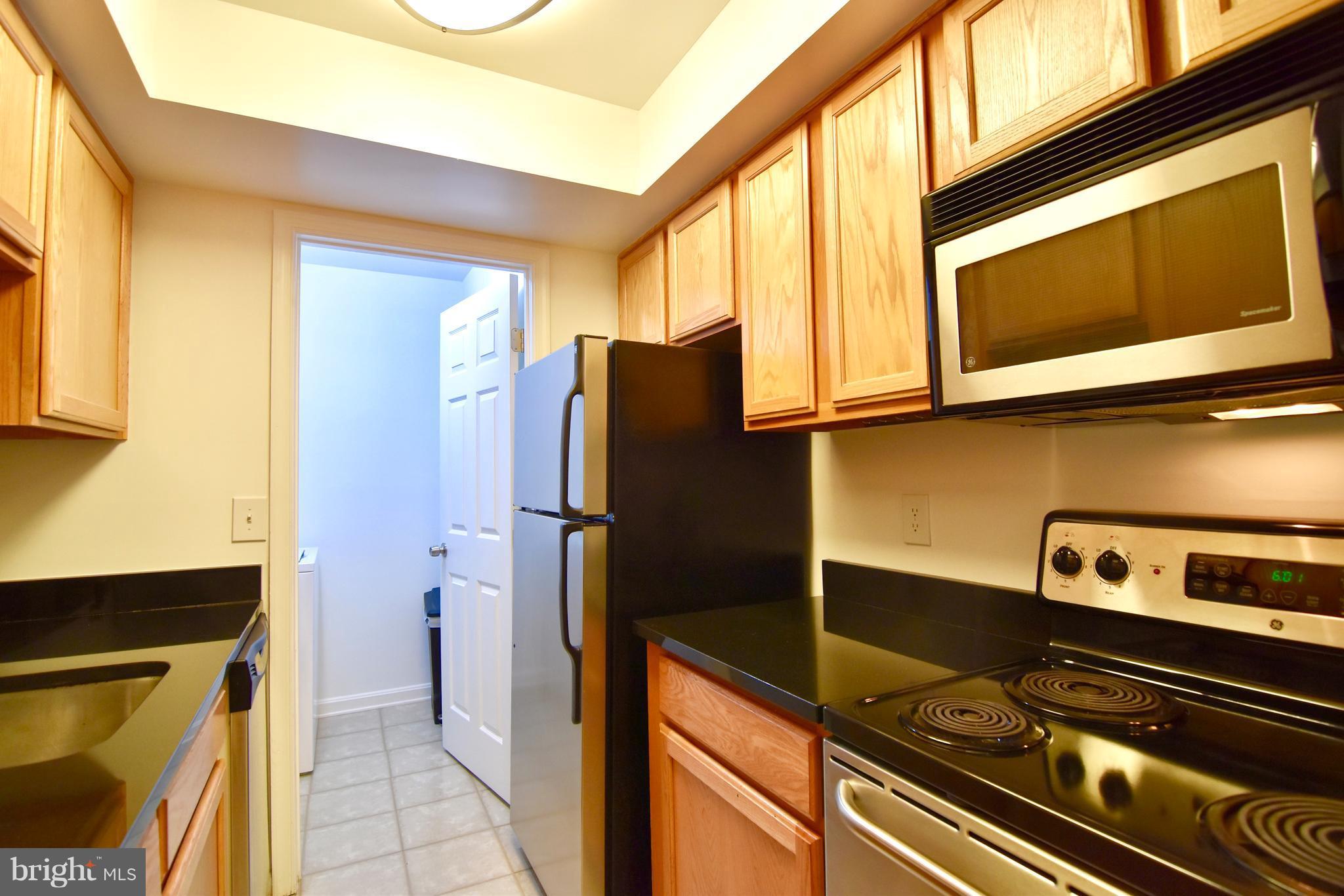 14903 Rydell Road, Unit 204 Centreville, VA 20121 - Photo 6 of 16 a kitchen with a refrigerator stove and microwave
