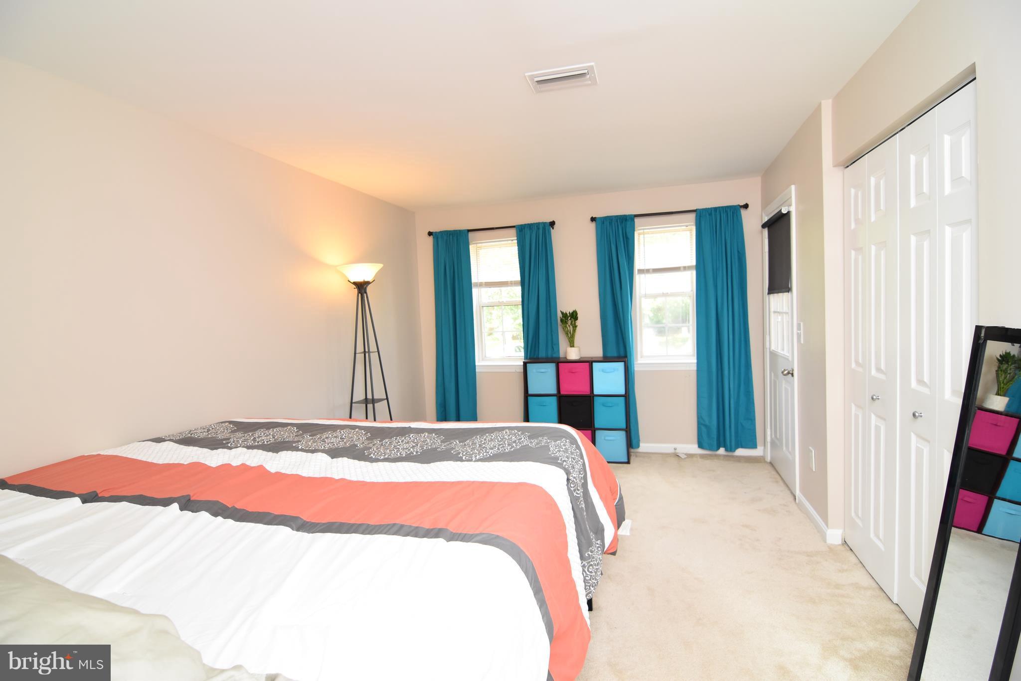 14903 Rydell Road, Unit 204 Centreville, VA 20121 - Photo 7 of 16 a bedroom with a bed and a large mirror next to a window