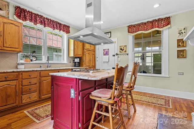 a dining hall with stainless steel appliances granite countertop a stove and a chair