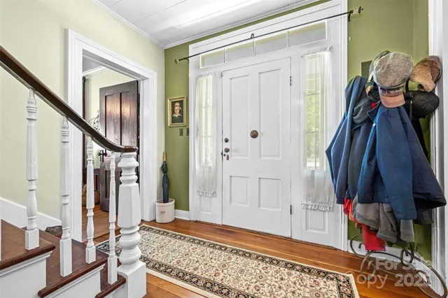 a view of an entryway with wooden floor and livingroom
