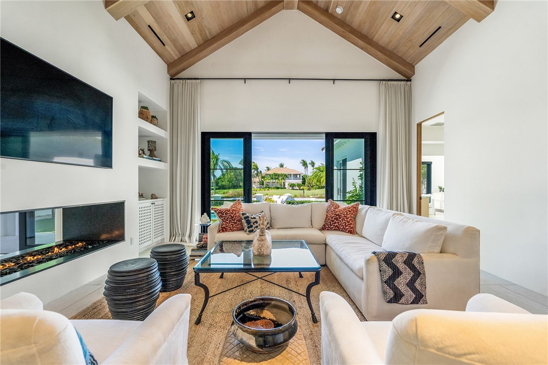 61 Caribe Way Vero Beach, FL 32963 - Photo 12 of 36 a living room with furniture a fireplace and a flat screen tv