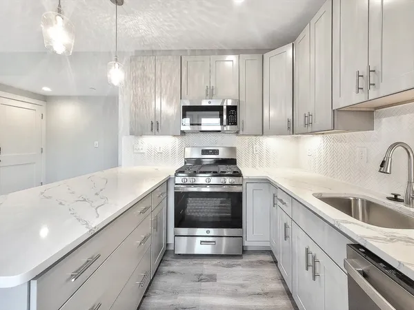 a kitchen with stainless steel appliances granite countertop a sink and a stove