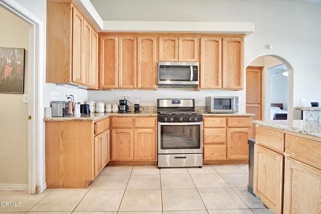 a kitchen with stainless steel appliances granite countertop a refrigerator and a stove top oven
