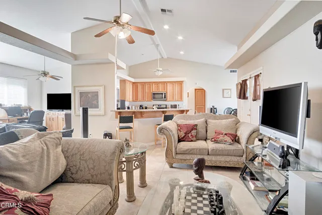 a living room with furniture a chandelier and a flat screen tv