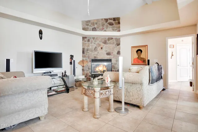 a living room with furniture a flat screen tv and a chandelier