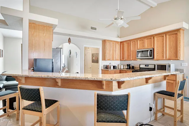 a large kitchen with granite countertop lots of counter top space and stainless steel appliances