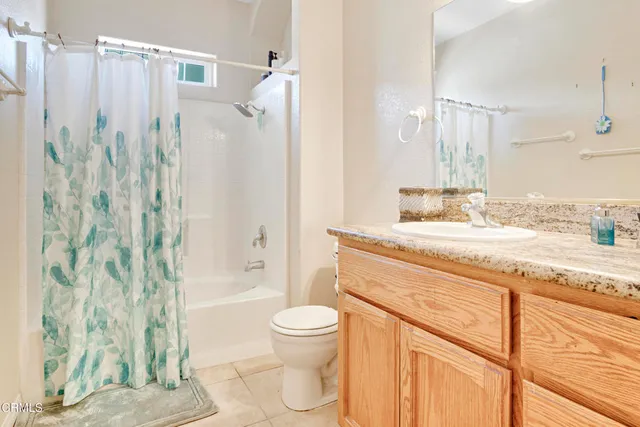a bathroom with a granite countertop sink toilet a mirror a vanity and shower