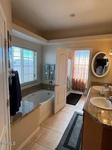 a bathroom with a granite countertop sink and a bathtub