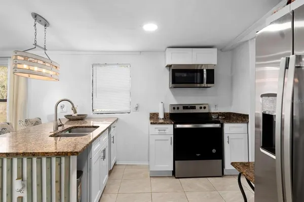 a kitchen with stainless steel appliances granite countertop a refrigerator and a stove top oven