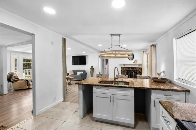 a kitchen with granite countertop a sink dishwasher stove and cabinets