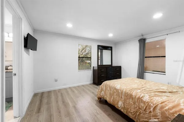 a spacious bedroom with a bed and a television