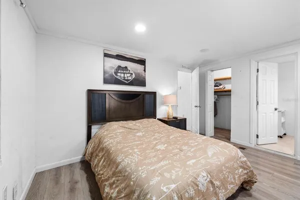 a bedroom with a bed and painting on the wall