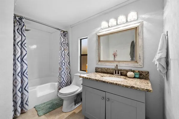 a bathroom with a granite countertop sink toilet a mirror and shower