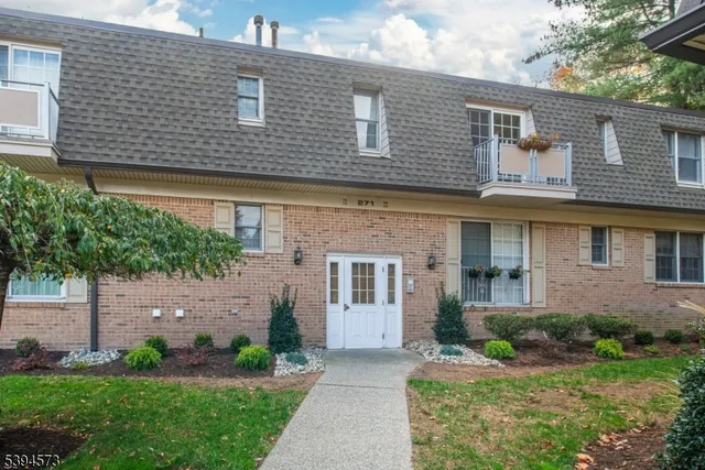 a front view of a house with a garden and plants