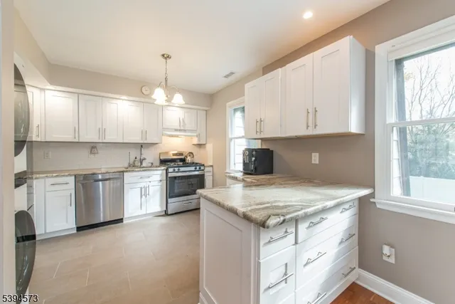 a kitchen with a stove a sink a center island and cabinets