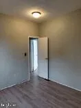 an empty room with wooden floor and closet