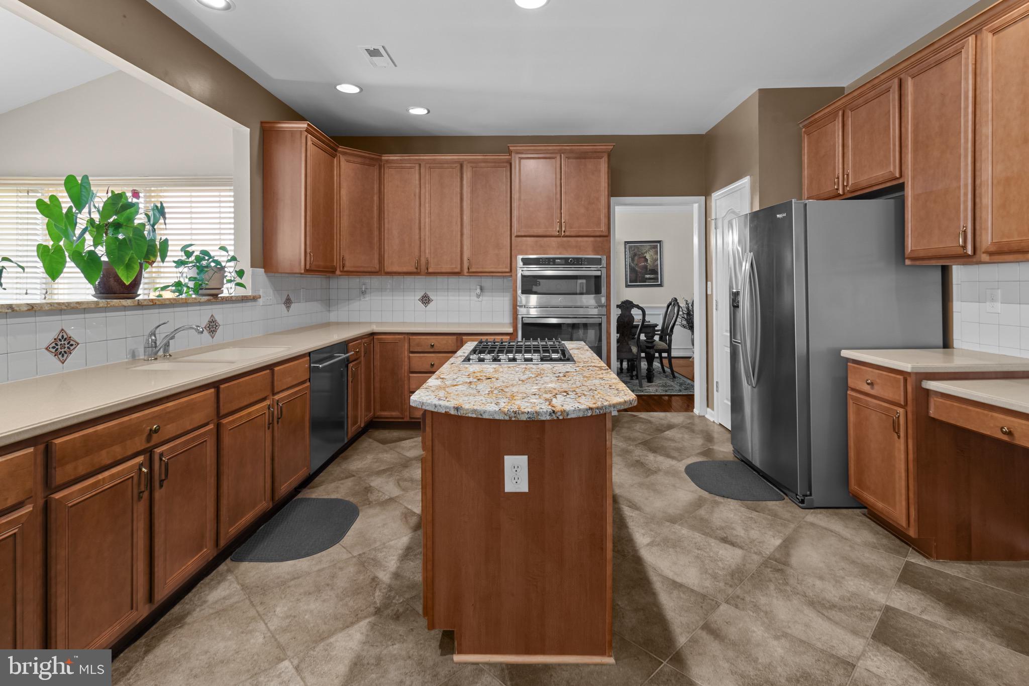 907 Mather Drive Bear, DE 19701 - Photo 30 of 80 a kitchen with stainless steel appliances granite countertop a refrigerator a sink dishwasher a stove with wooden cabinets and a stove