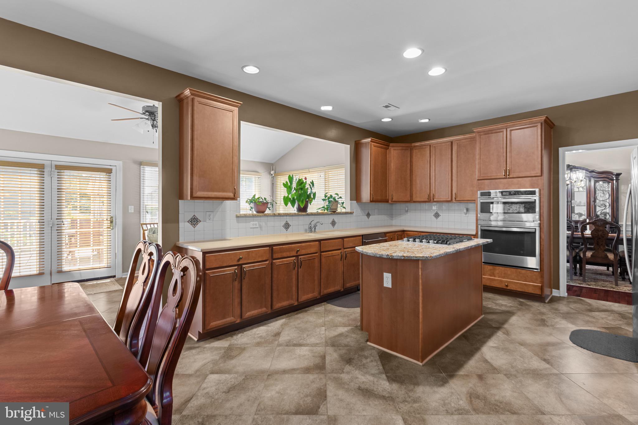 907 Mather Drive Bear, DE 19701 - Photo 32 of 80 a kitchen with stainless steel appliances granite countertop a stove a sink a oven a dining table and chairs