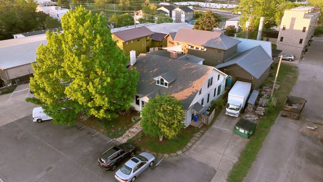 a front view of a house with a garden and trees