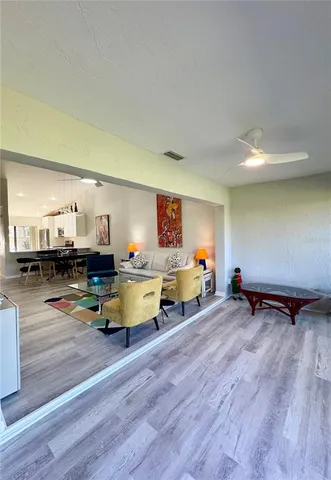 a kitchen with stainless steel appliances kitchen island granite countertop a table chairs a sink and a refrigerator