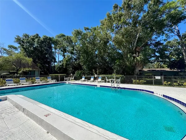 a kitchen with stainless steel appliances kitchen island granite countertop a table chairs a sink and a refrigerator