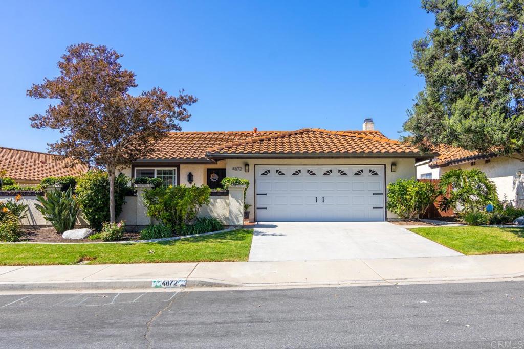 a front view of a house with a yard and a garage
