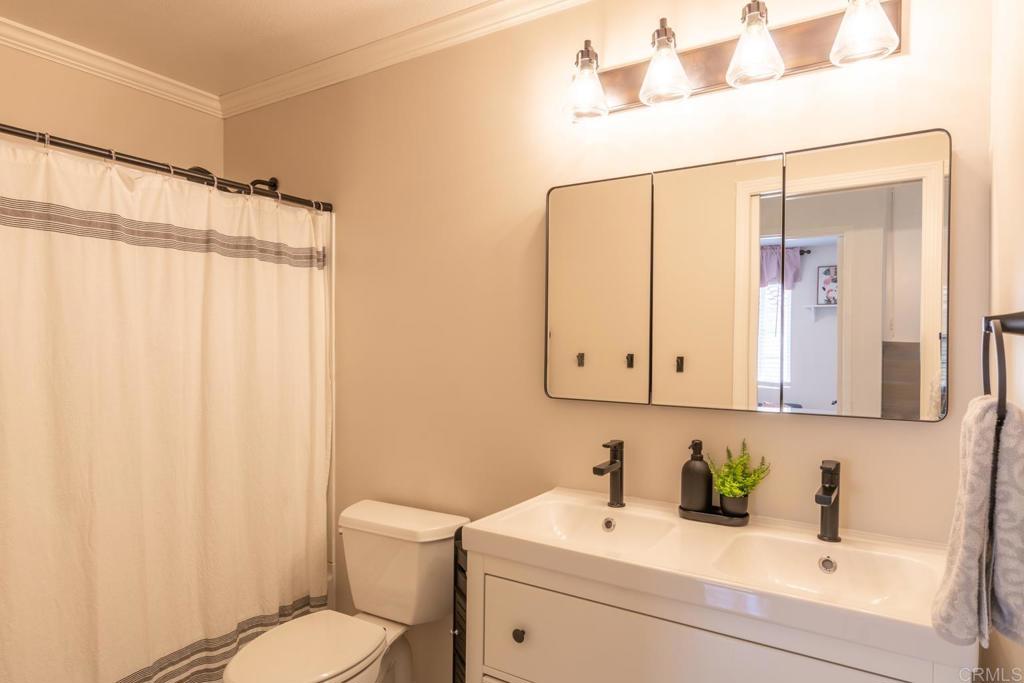 4872 Tarragon Drive Oceanside, CA 92057 - Photo 12 of 25 a bathroom with a sink a toilet and a mirror